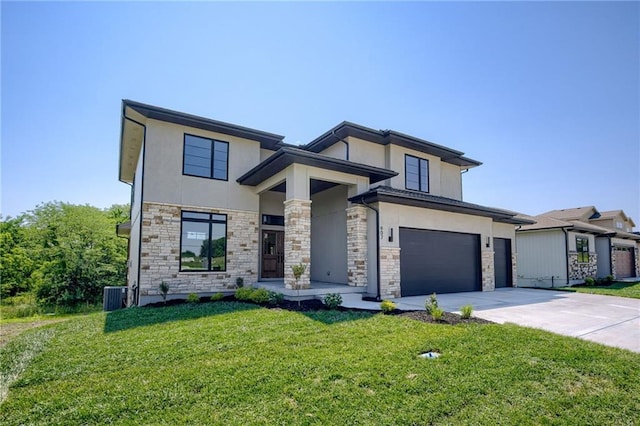 907 Reed Dr, Raymore, MO 64083 - view of front facade featuring stucco siding, concrete driveway, stone siding, a front yard, and a garage
