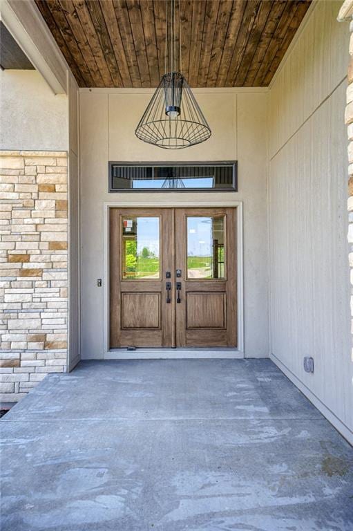 907 Reed Dr, Raymore, MO 64083 - property entrance featuring french doors and stone siding
