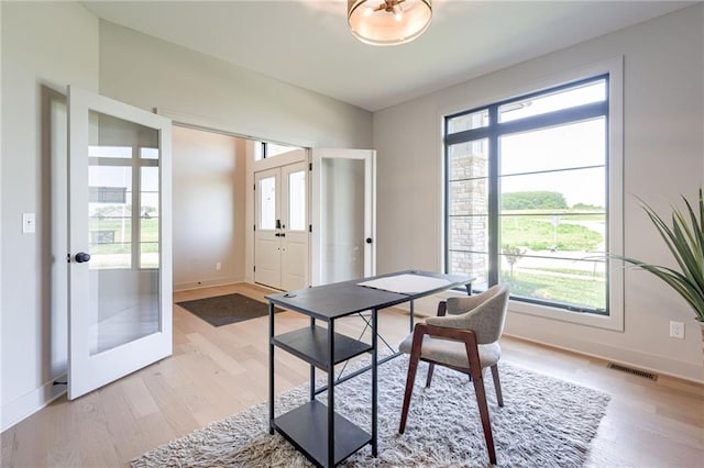 907 Reed Dr, Raymore, MO 64083 - home office featuring french doors, plenty of natural light, and light wood-style flooring