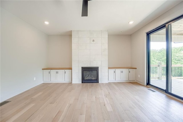 907 Reed Dr, Raymore, MO 64083 - unfurnished living room featuring light wood-style floors, a fireplace, recessed lighting, and a ceiling fan
