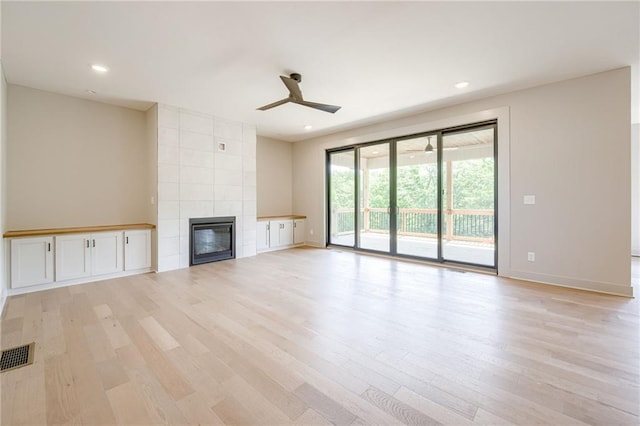 907 Reed Dr, Raymore, MO 64083 - unfurnished living room with ceiling fan, light wood-style floors, a tile fireplace, and recessed lighting