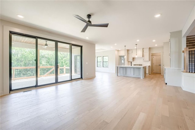907 Reed Dr, Raymore, MO 64083 - unfurnished living room with ceiling fan, light wood finished floors, and recessed lighting