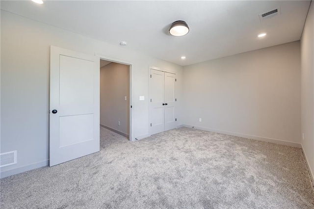 907 Reed Dr, Raymore, MO 64083 - unfurnished bedroom featuring carpet floors, a closet, and recessed lighting