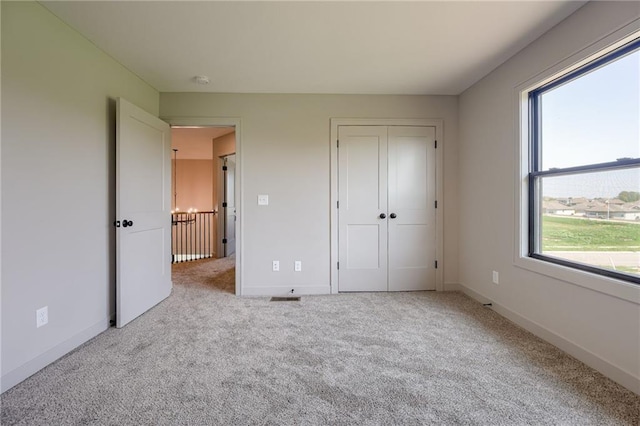 907 Reed Dr, Raymore, MO 64083 - unfurnished bedroom featuring carpet flooring and a closet