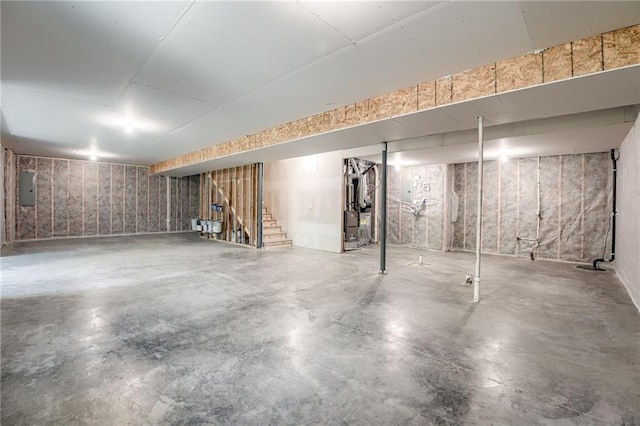 907 Reed Dr, Raymore, MO 64083 - unfinished below grade area featuring electric panel and stairway
