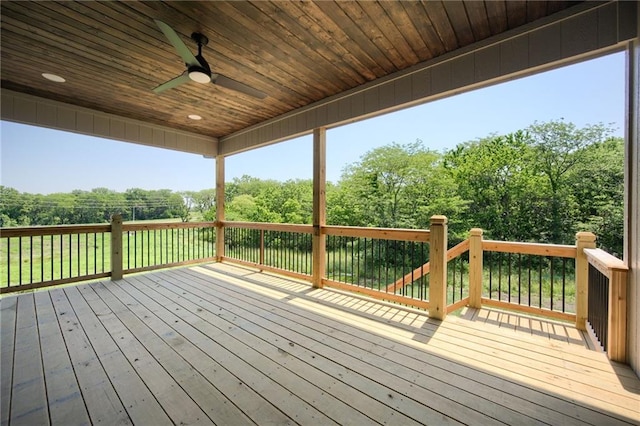 907 Reed Dr, Raymore, MO 64083 - wooden deck with a ceiling fan and view of wooded area