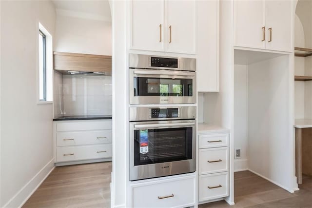 17041 Earnshaw St, Overland Park, KS 66221 - kitchen featuring stainless steel double oven, light wood-style floors, white cabinets, and light countertops