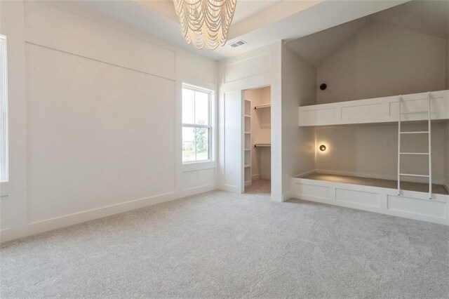 17041 Earnshaw St, Overland Park, KS 66221 - unfurnished bedroom featuring a chandelier, light colored carpet, lofted ceiling, and a spacious closet
