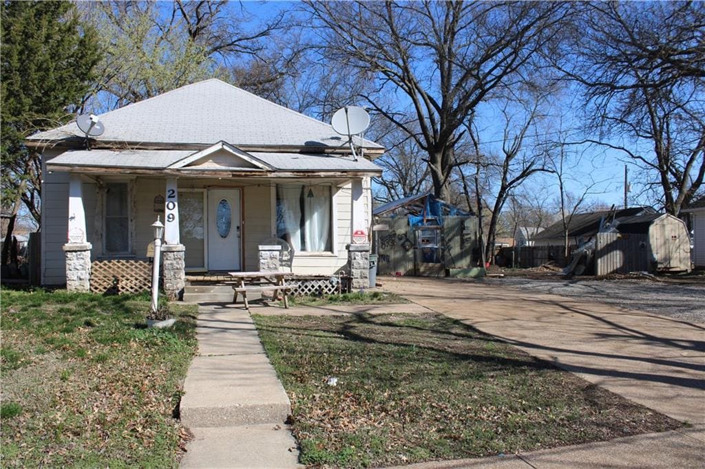 view of front of house featuring an outbuilding, a porch, and a storage unit