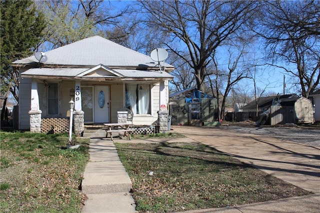 view of front of house featuring an outbuilding, a porch, and a storage unit