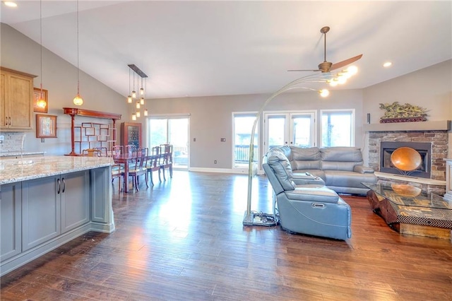 11237 S Race St, Olathe, KS 66061 - living area with vaulted ceiling, a ceiling fan, dark wood-style flooring, a stone fireplace, and recessed lighting