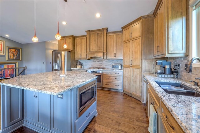 11237 S Race St, Olathe, KS 66061 - kitchen featuring appliances with stainless steel finishes, a kitchen island, backsplash, dark wood-style floors, and brown cabinetry