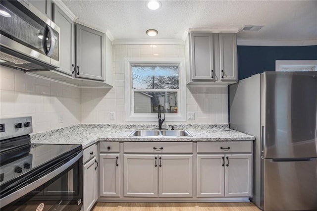 203 N Chestnut St, Pittsburg, KS 66762 - kitchen featuring crown molding, appliances with stainless steel finishes, a sink, and gray cabinetry