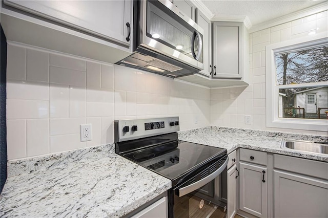 203 N Chestnut St, Pittsburg, KS 66762 - kitchen with crown molding, decorative backsplash, appliances with stainless steel finishes, and gray cabinetry