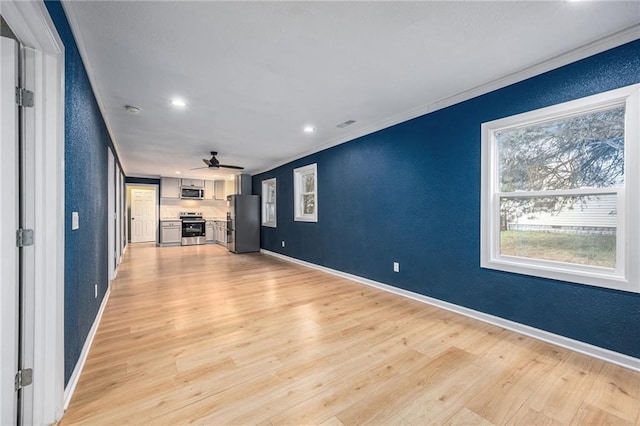 203 N Chestnut St, Pittsburg, KS 66762 - unfurnished living room featuring a textured wall, light wood finished floors, a ceiling fan, and ornamental molding