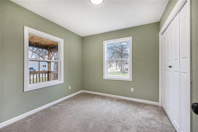 203 N Chestnut St, Pittsburg, KS 66762 - unfurnished bedroom featuring a closet, carpet flooring, baseboards, and multiple windows