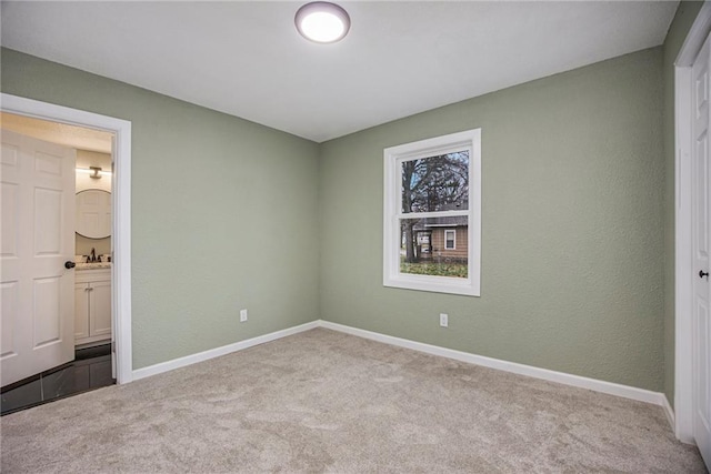 203 N Chestnut St, Pittsburg, KS 66762 - unfurnished bedroom with ensuite bath, baseboards, and carpet floors
