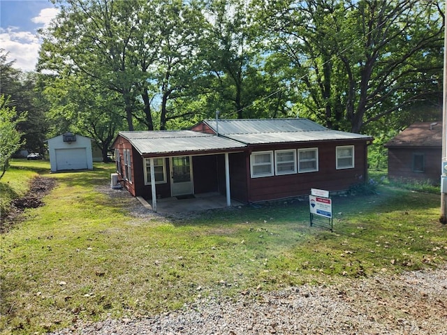 29243 Serene Ave, Warsaw, MO 65355 - view of front facade featuring a front lawn, metal roof, a detached garage, and an outdoor structure