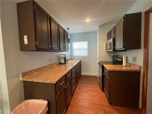 29243 Serene Ave, Warsaw, MO 65355 - kitchen featuring appliances with stainless steel finishes, a sink, wood finished floors, and dark brown cabinets