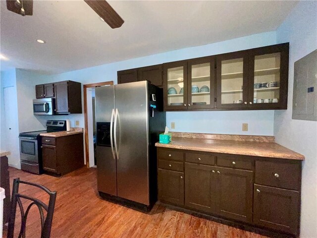 29243 Serene Ave, Warsaw, MO 65355 - kitchen featuring appliances with stainless steel finishes, light wood-type flooring, dark brown cabinetry, electric panel, and glass insert cabinets