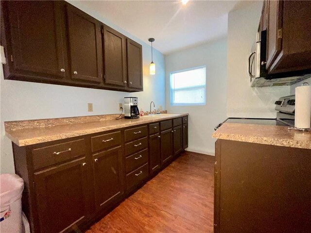 29243 Serene Ave, Warsaw, MO 65355 - kitchen with wood finished floors, a sink, electric range, dark brown cabinetry, and light countertops