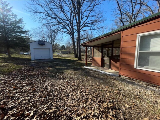 29243 Serene Ave, Warsaw, MO 65355 - view of yard featuring a garage, an outbuilding, and a sunroom