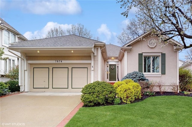 view of front of home with a front yard, concrete driveway, an attached garage, a shingled roof, and stucco siding