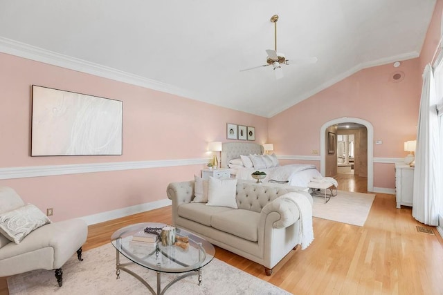 living room featuring arched walkways, ceiling fan, ornamental molding, wood finished floors, and lofted ceiling