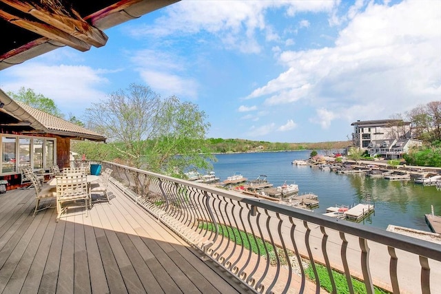 wooden deck featuring a water view and outdoor dining area