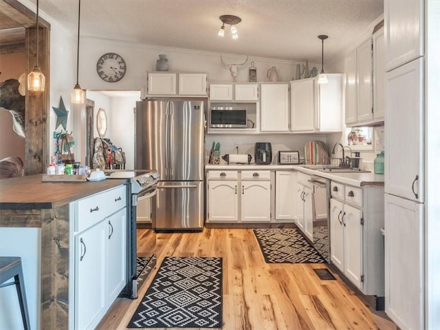 14199 County Road 191, Savannah, MO 64485 - kitchen featuring pendant lighting, white cabinets, stainless steel appliances, and light wood finished floors