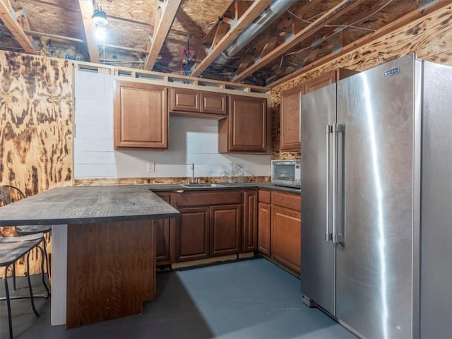 14199 County Road 191, Savannah, MO 64485 - kitchen featuring a peninsula, dark countertops, appliances with stainless steel finishes, a sink, and a breakfast bar area