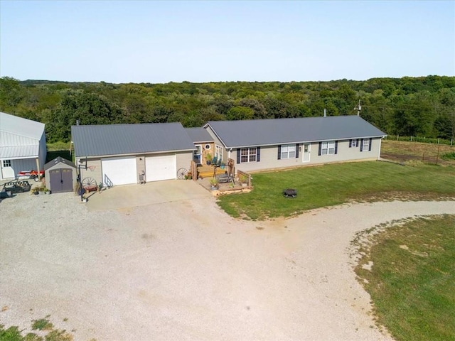 14199 County Road 191, Savannah, MO 64485 - single story home with gravel driveway, a front lawn, a garage, a view of trees, and a storage shed