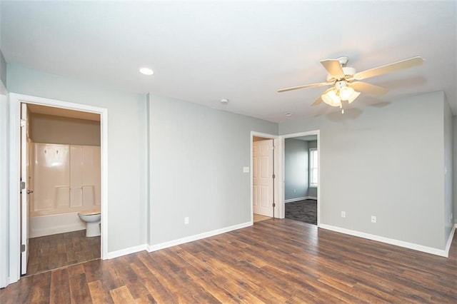 unfurnished bedroom featuring wood finished floors, baseboards, and ensuite bathroom
