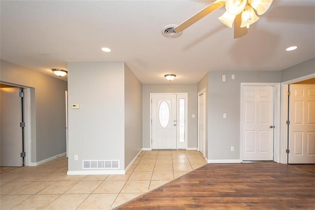 foyer entrance with light tile patterned floors, visible vents, baseboards, and ceiling fan