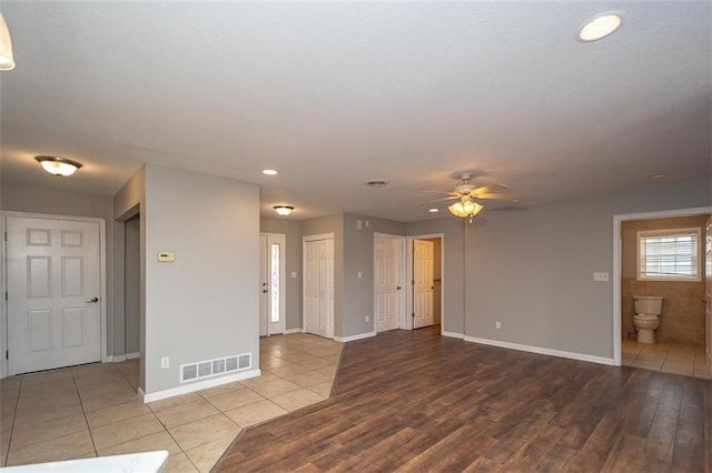 unfurnished room featuring tile patterned floors, visible vents, baseboards, and ceiling fan