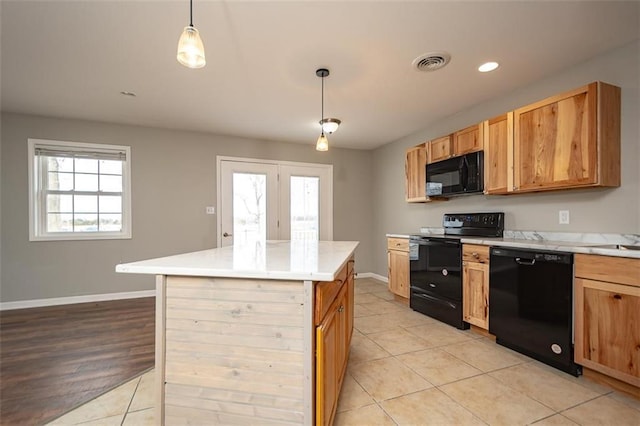kitchen featuring visible vents, baseboards, black appliances, and light countertops