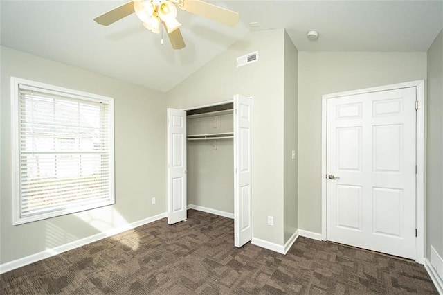 unfurnished bedroom featuring visible vents, baseboards, lofted ceiling, and dark colored carpet