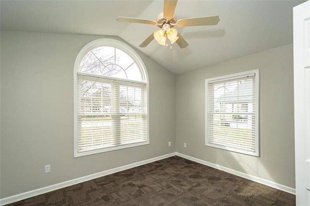empty room featuring a healthy amount of sunlight, baseboards, lofted ceiling, and a ceiling fan