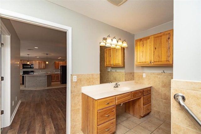 bathroom featuring a wainscoted wall, tile walls, vanity, and tile patterned flooring