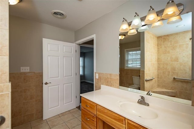 full bath with tile patterned floors, visible vents, toilet, tile walls, and vanity