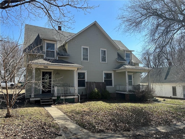 236 N Liberty St, Troy, KS 66087 - view of front of home featuring a porch, roof with shingles, and a chimney