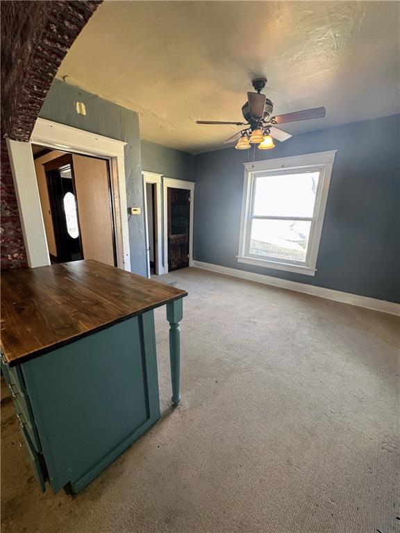 236 N Liberty St, Troy, KS 66087 - unfurnished living room with baseboards, a ceiling fan, and carpet flooring