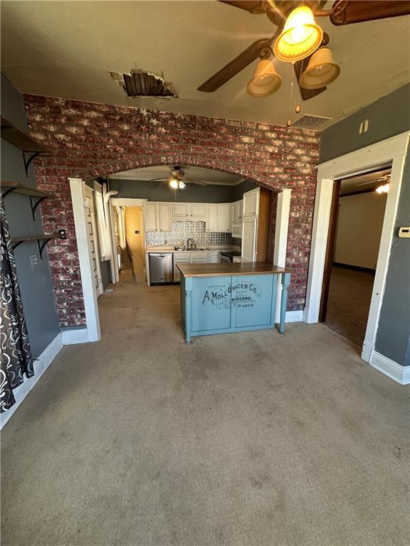 236 N Liberty St, Troy, KS 66087 - kitchen with a ceiling fan, white cabinetry, appliances with stainless steel finishes, a peninsula, and light colored carpet