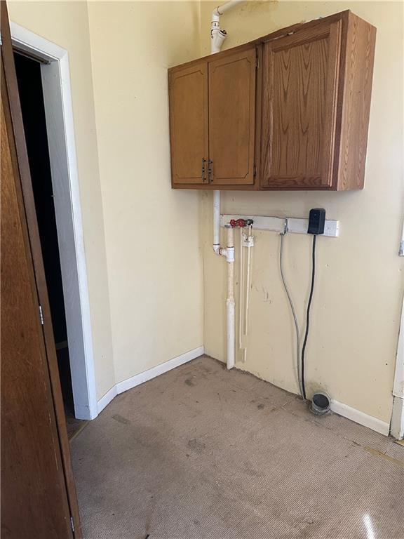 236 N Liberty St, Troy, KS 66087 - laundry room with baseboards, cabinet space, and light carpet