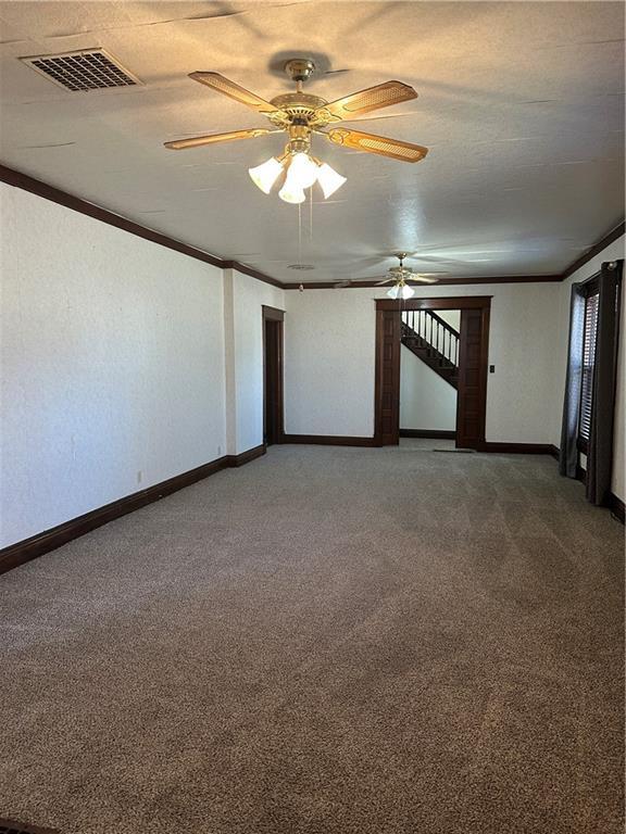 236 N Liberty St, Troy, KS 66087 - carpeted spare room featuring baseboards, a ceiling fan, visible vents, and ornamental molding