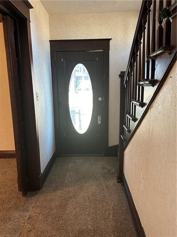 236 N Liberty St, Troy, KS 66087 - carpeted foyer with stairway, baseboards, and a textured wall