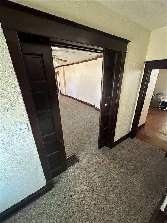 236 N Liberty St, Troy, KS 66087 - corridor featuring a textured wall, visible vents, carpet floors, and baseboards