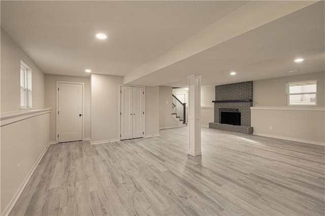 14401 67th St, Parkville, MO 64152 - basement with baseboards, plenty of natural light, stairs, light wood-style floors, and a brick fireplace