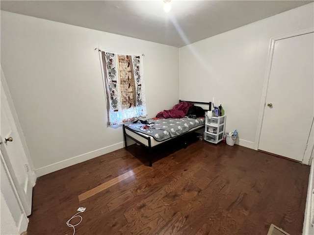 bedroom with wood finished floors and baseboards