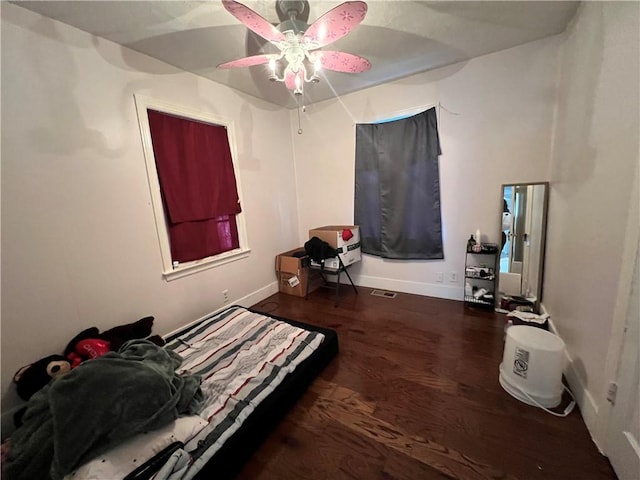 bedroom featuring baseboards, a ceiling fan, and wood finished floors